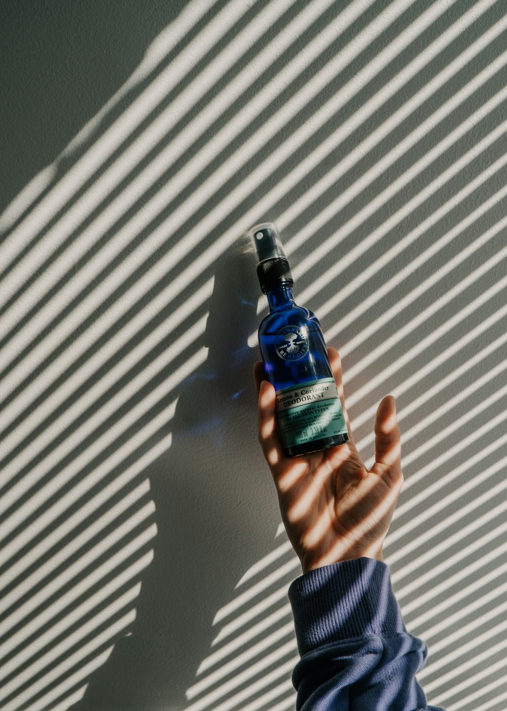 person holding blue and black bottle