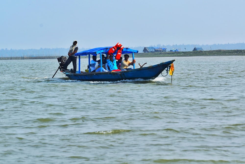 people riding on blue boat during daytime