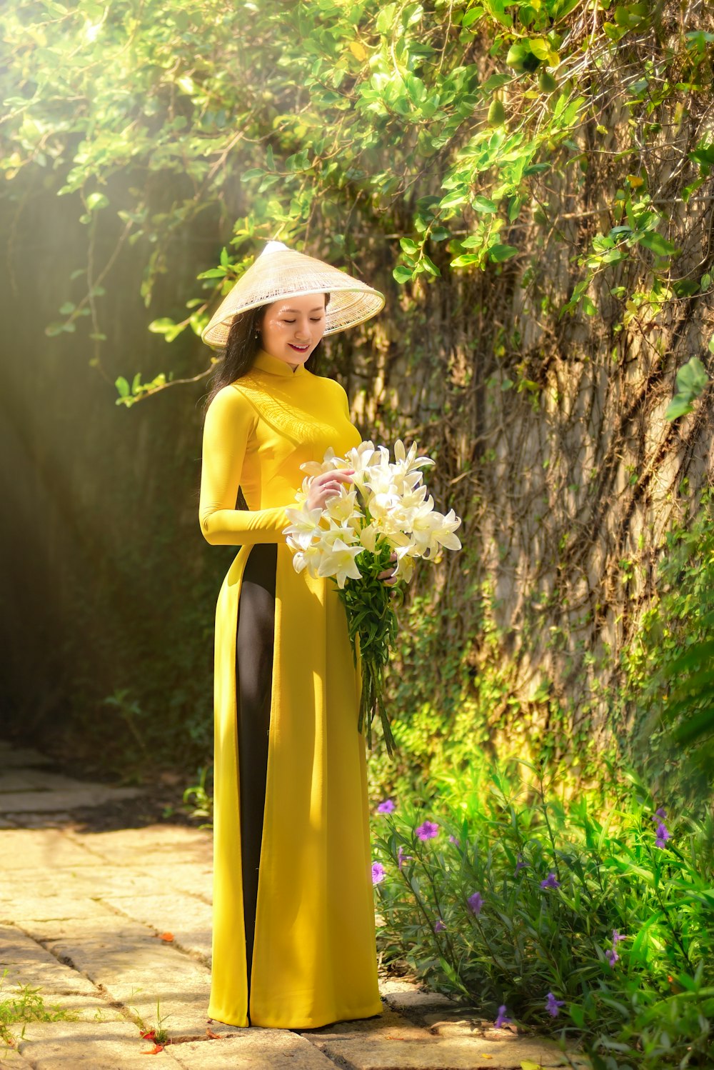 woman in yellow sleeveless dress holding white flower bouquet