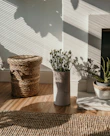 A round braided jute farmhouse rug placed in a bright, airy room with natural light.