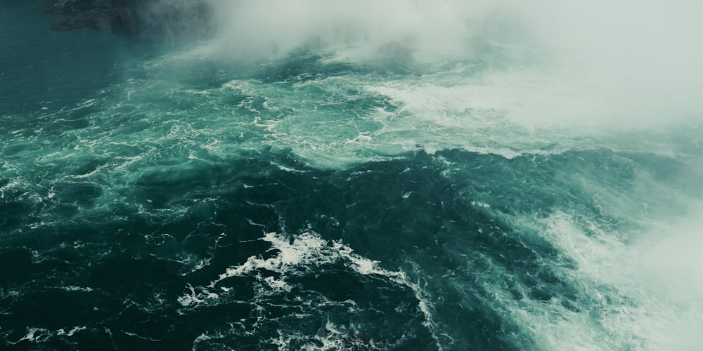 ocean waves crashing on rocks during daytime