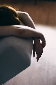 Person resting on a couch, looking visibly tired and fatigued.