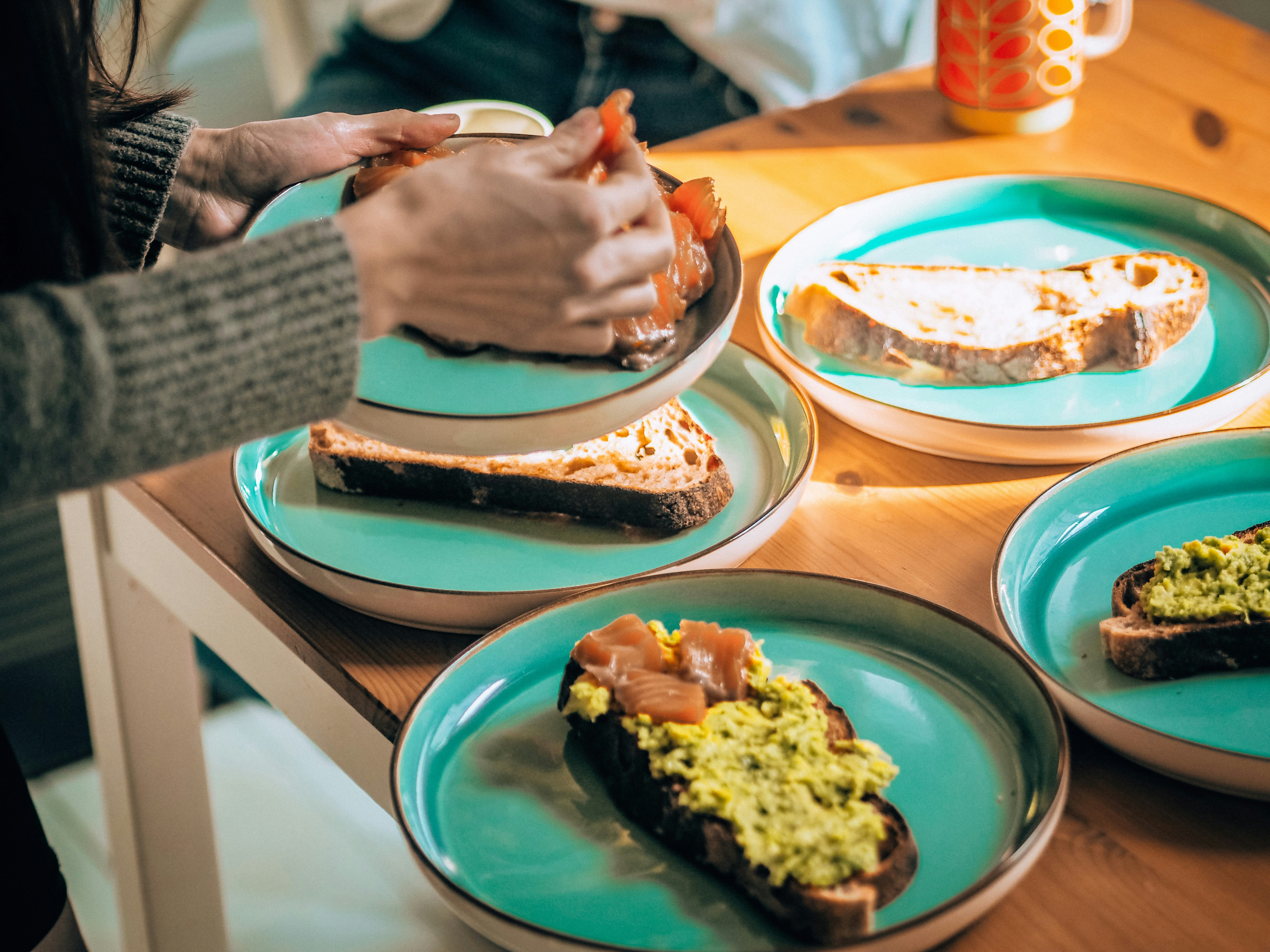Hands sharing toast plates on a table