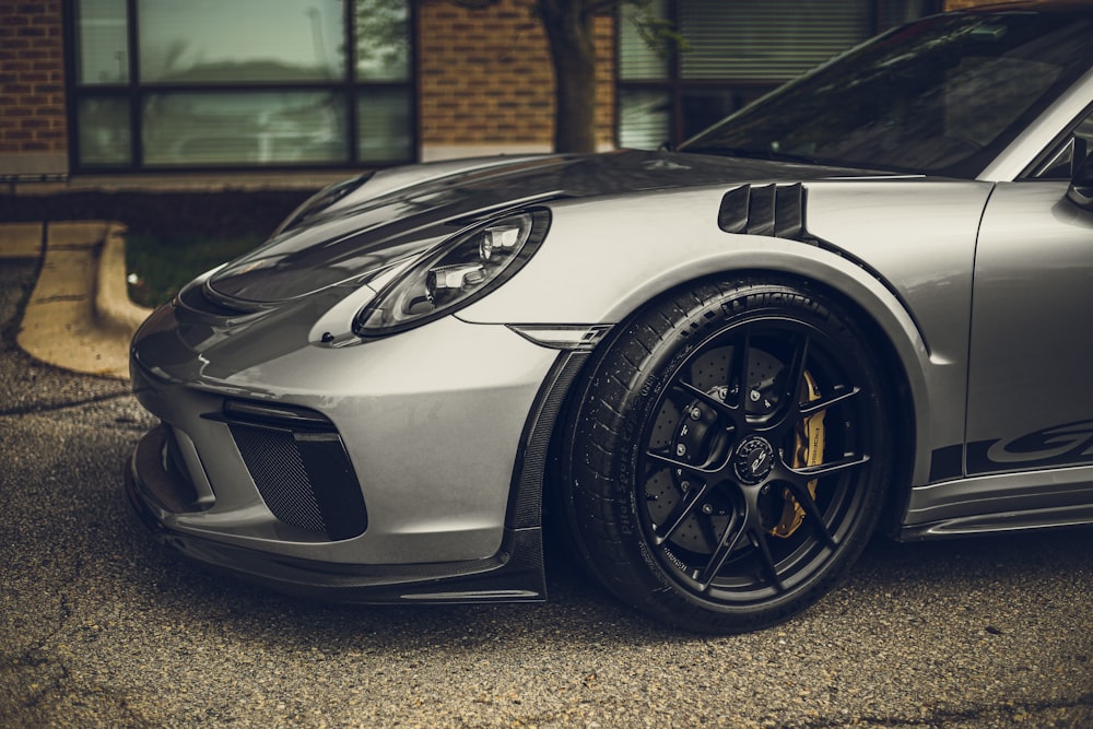 white porsche 911 parked on grey pavement during daytime