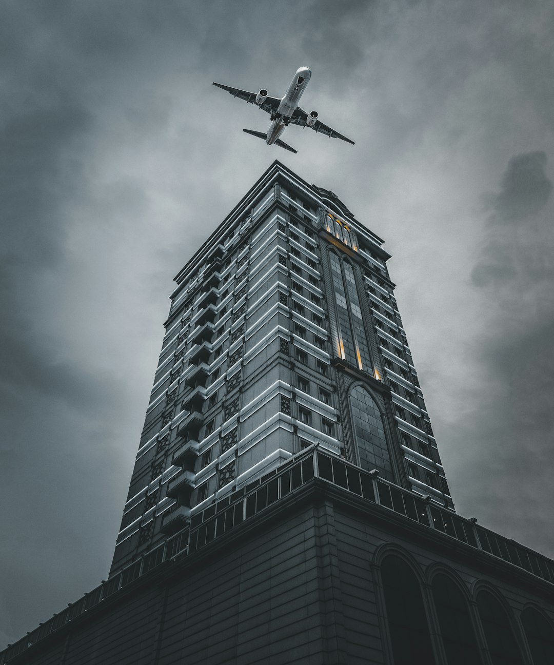 low angle photography of black and white concrete building under gray clouds