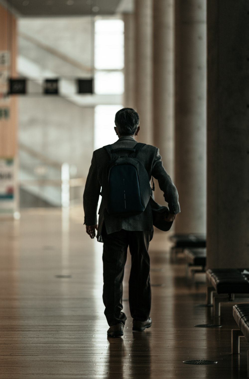 man in blue long sleeve shirt and black pants walking on hallway
