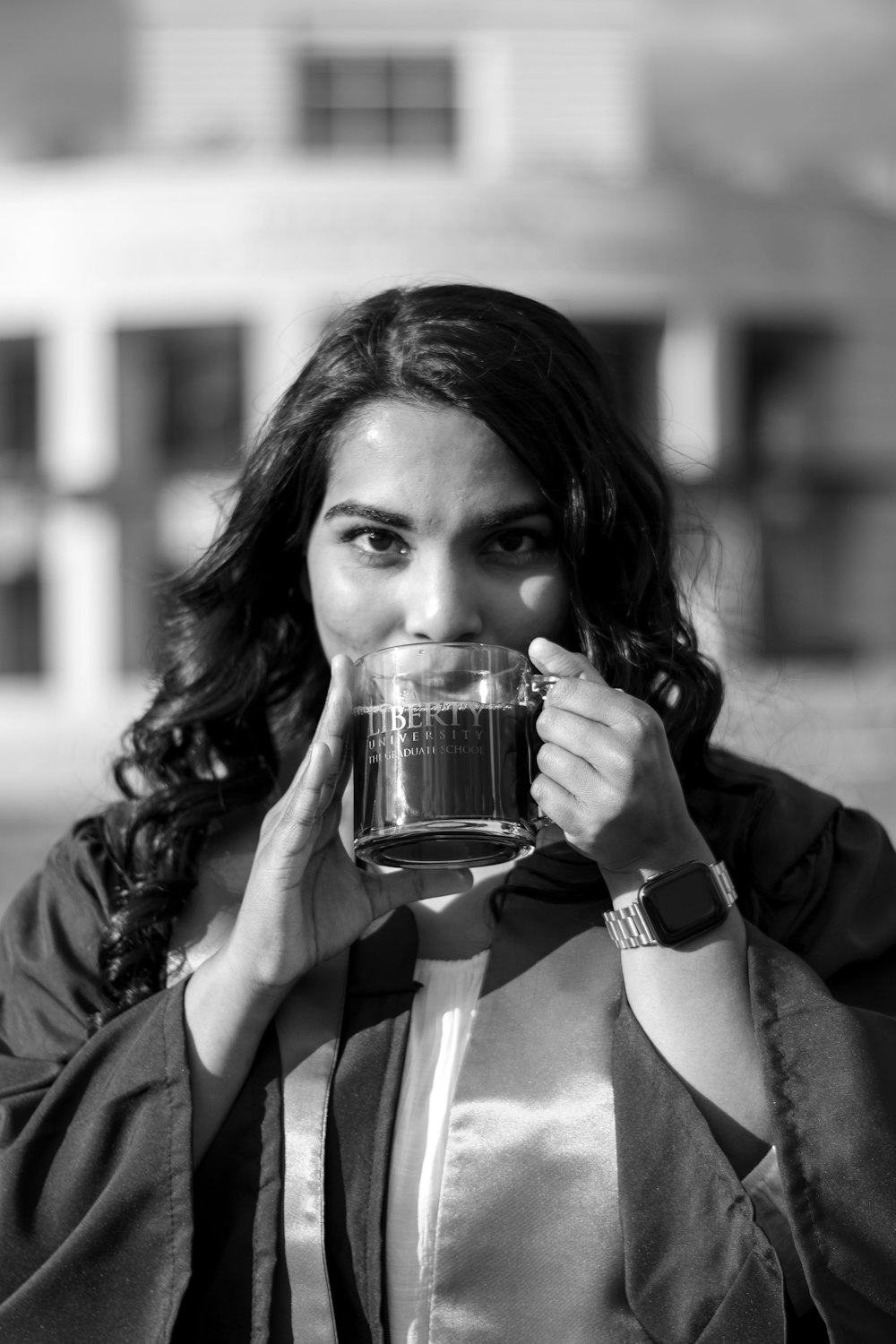 woman in black jacket holding clear drinking glass