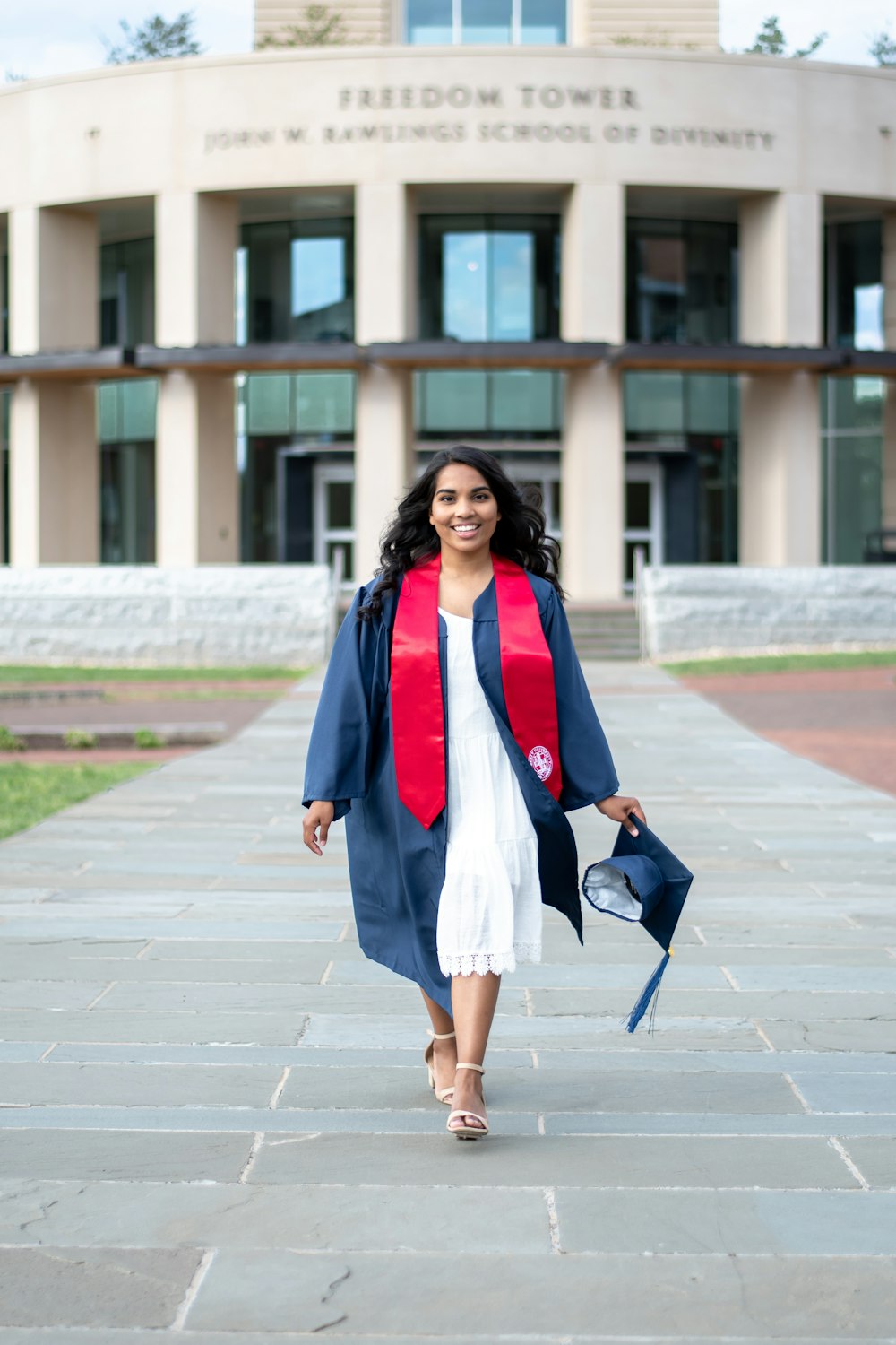 woman in pink blazer and blue denim skirt standing on sidewalk during daytime