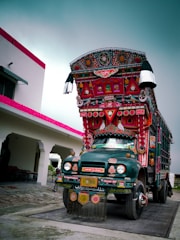 A colorful mobile art trailer parked in a sunny outdoor setting with people enjoying art activities.