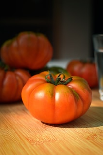 A vibrant row of freshly harvested heirloom tomatoes glistening under the morning sun at urbadfn chxsfarm llc.