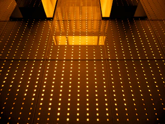 Golden geometric matrices glowing faintly in the dark, resembling a high-tech compass overlay.