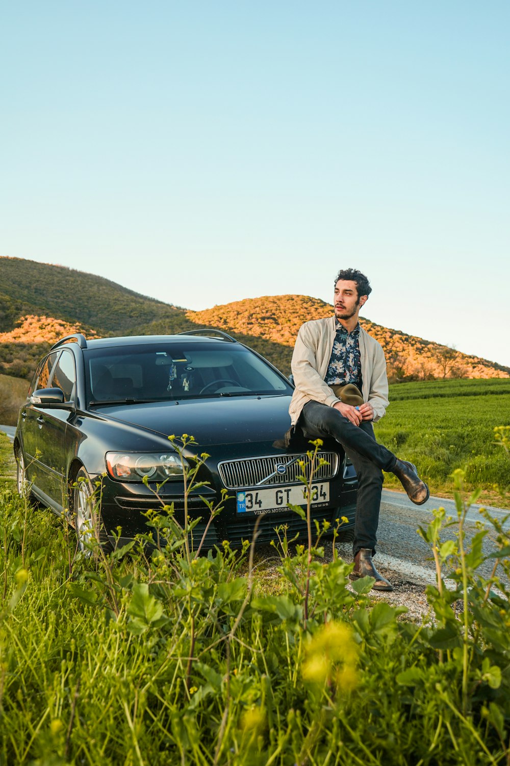 a man sitting on the hood of a car