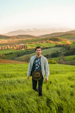 man in blue jacket standing on green grass field during daytime