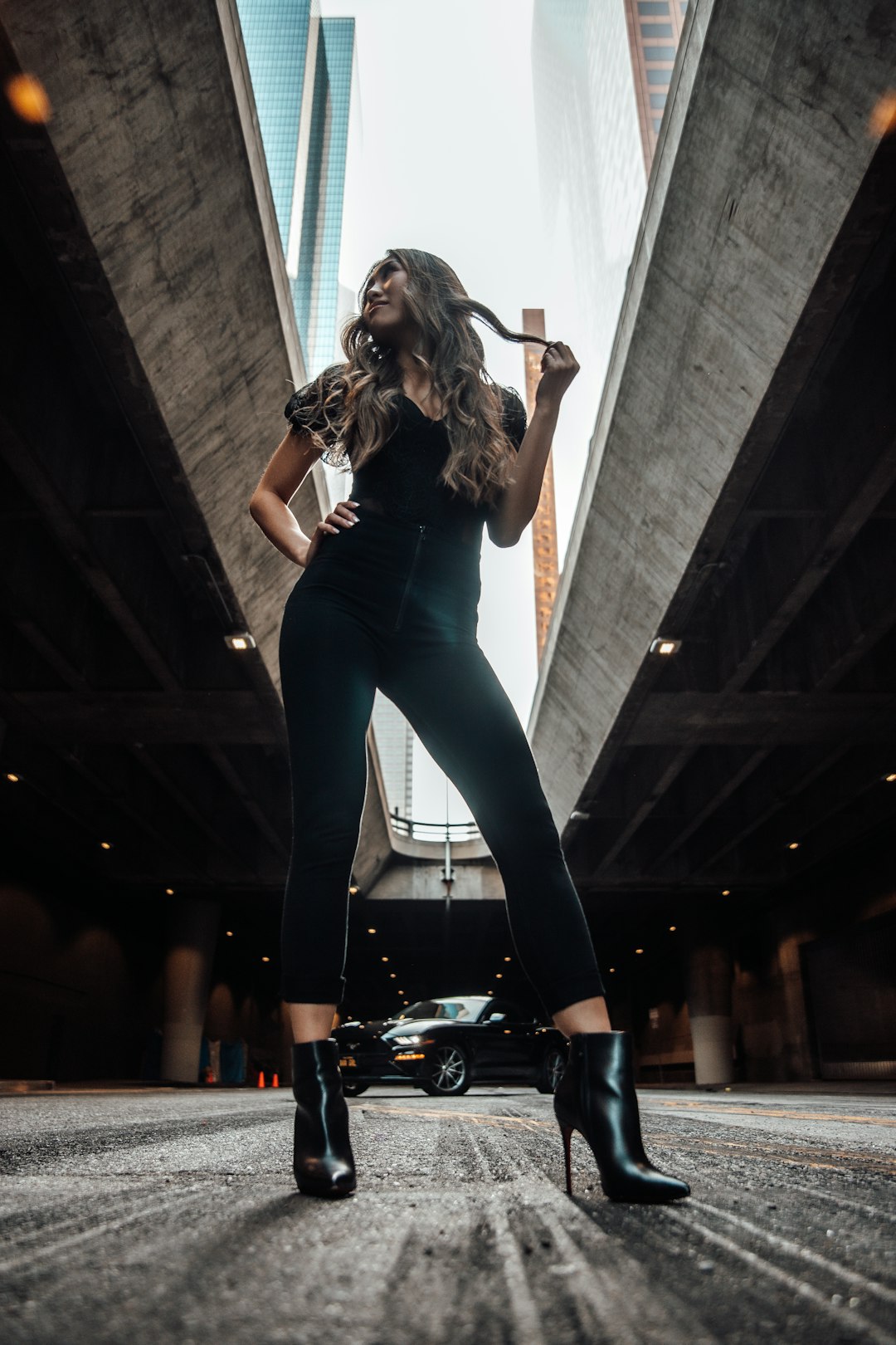 woman in black tank top and blue denim jeans singing on stage