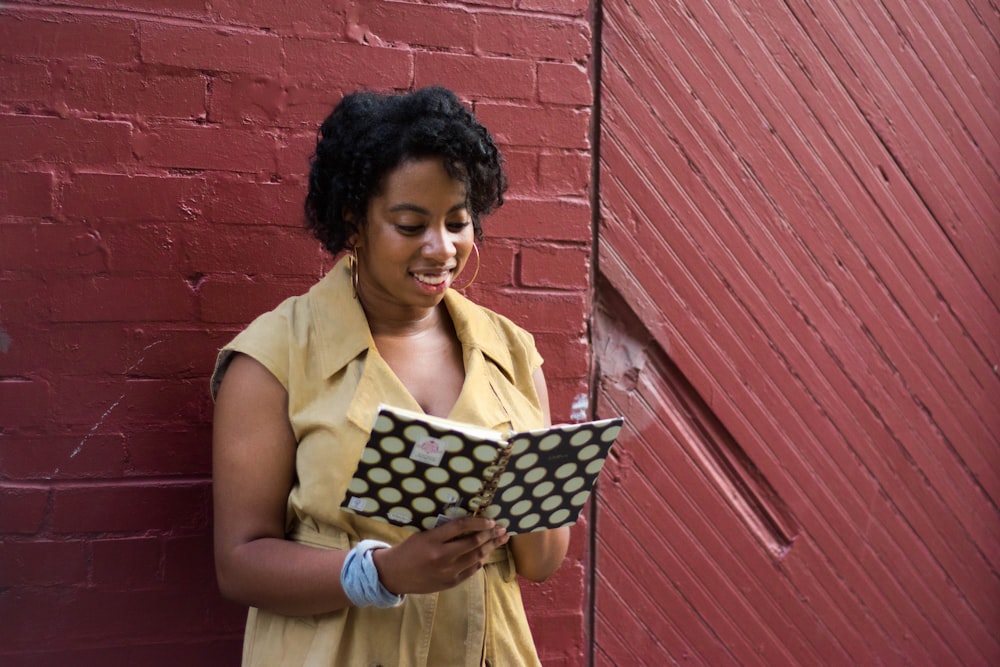 woman in yellow shirt holding black and white polka dot textile