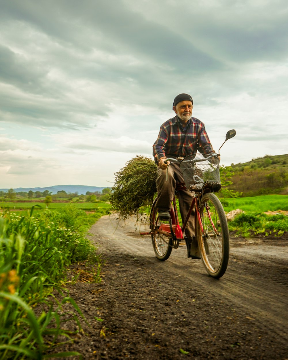 man in brown jacket riding bicycle on road during daytime