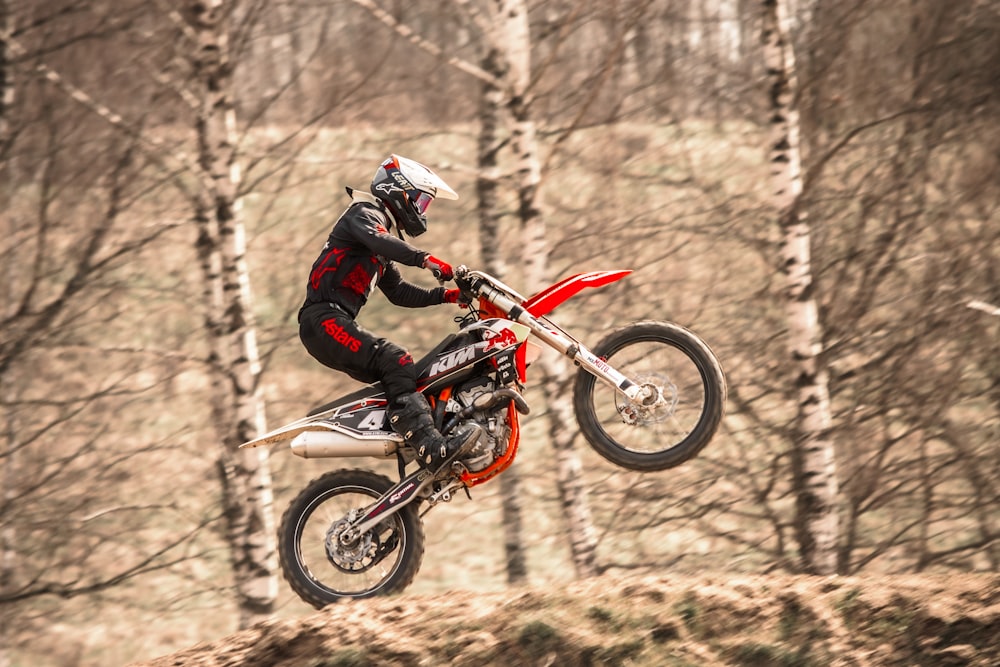 homem na jaqueta preta que monta motocross bicicleta de terra