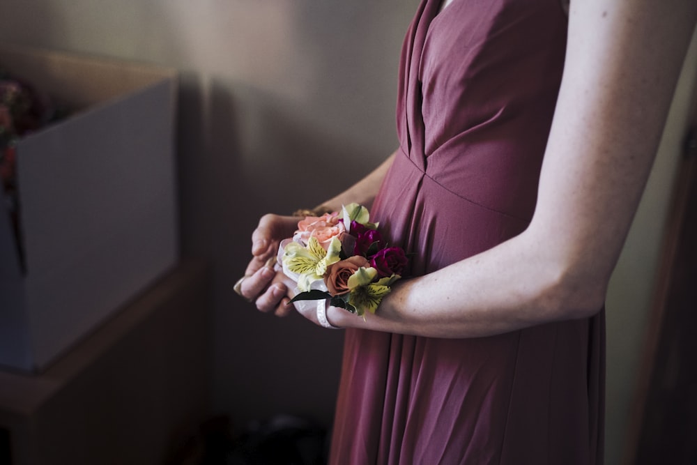 woman in pink dress holding bouquet of flowers