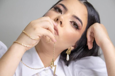 woman in white shirt wearing gold necklace
