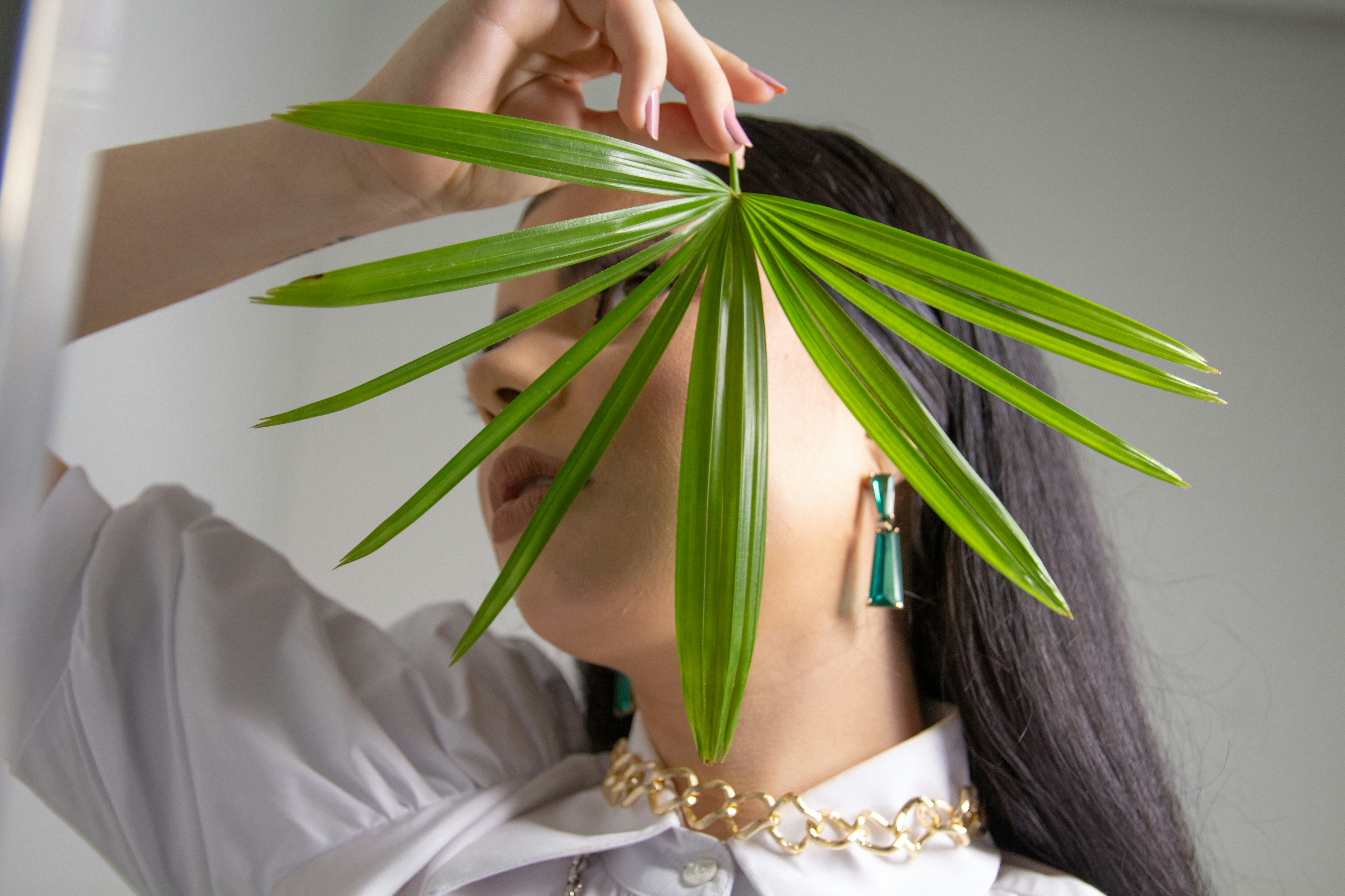 woman in white dress holding her green hair