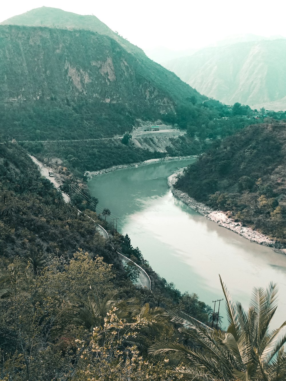 river between green mountains during daytime