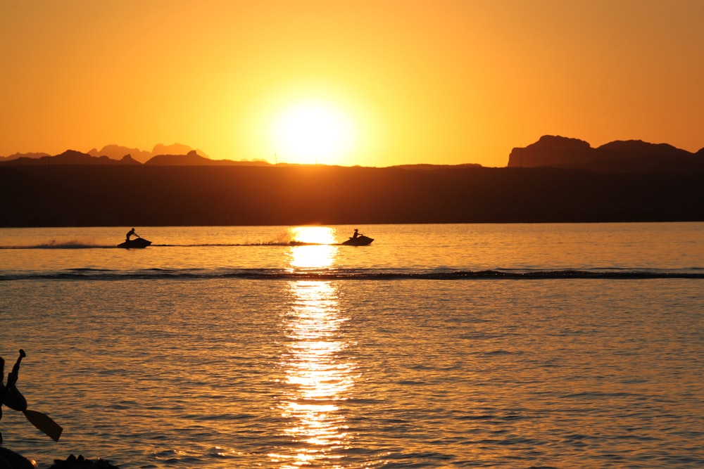 silhouette of person riding on boat during sunset