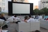 Children sitting on bean bags enjoying popcorn during an outdoor film.