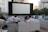 A cozy outdoor movie night scene with friends seated on blankets, a large screen glowing softly in the twilight.