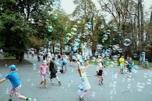Children playing happily in a park with their parents watching.