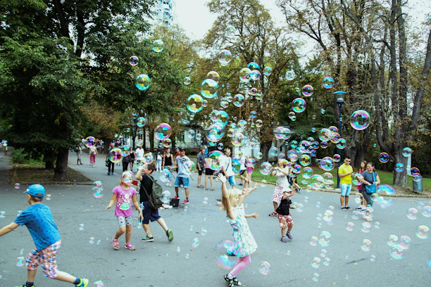 A vibrant scene of children joyfully playing with colorful foam water balls in a sunny backyard.