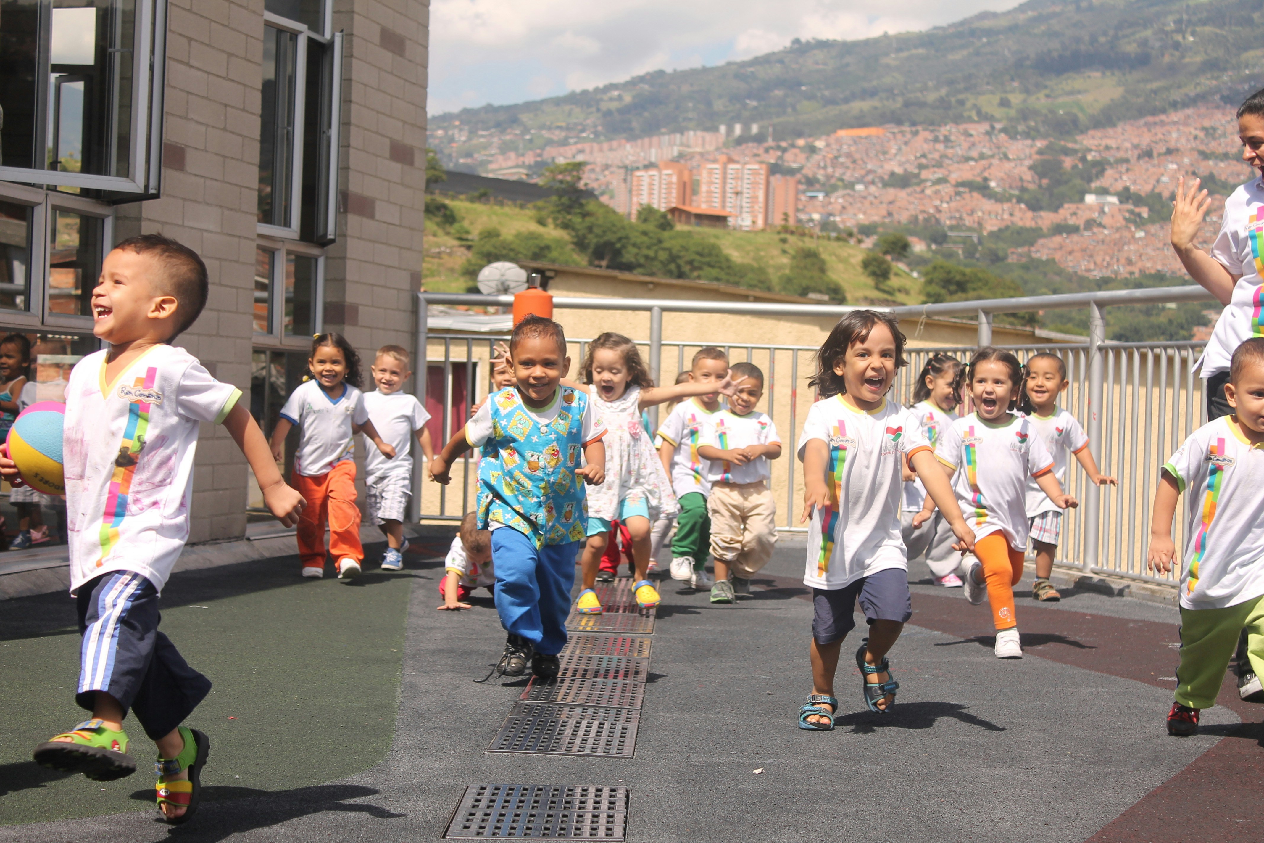 Group of children laughing and playing outdoors, bright daylight, open field, warm community atmosphere