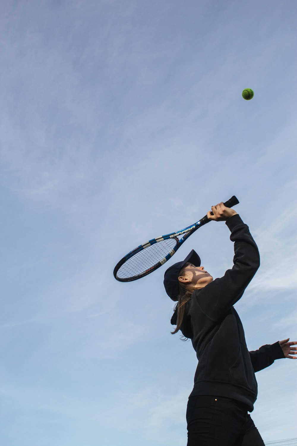 man in black jacket holding tennis racket