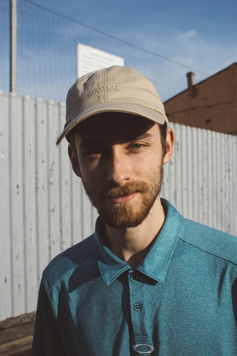 man in blue polo shirt wearing white cap