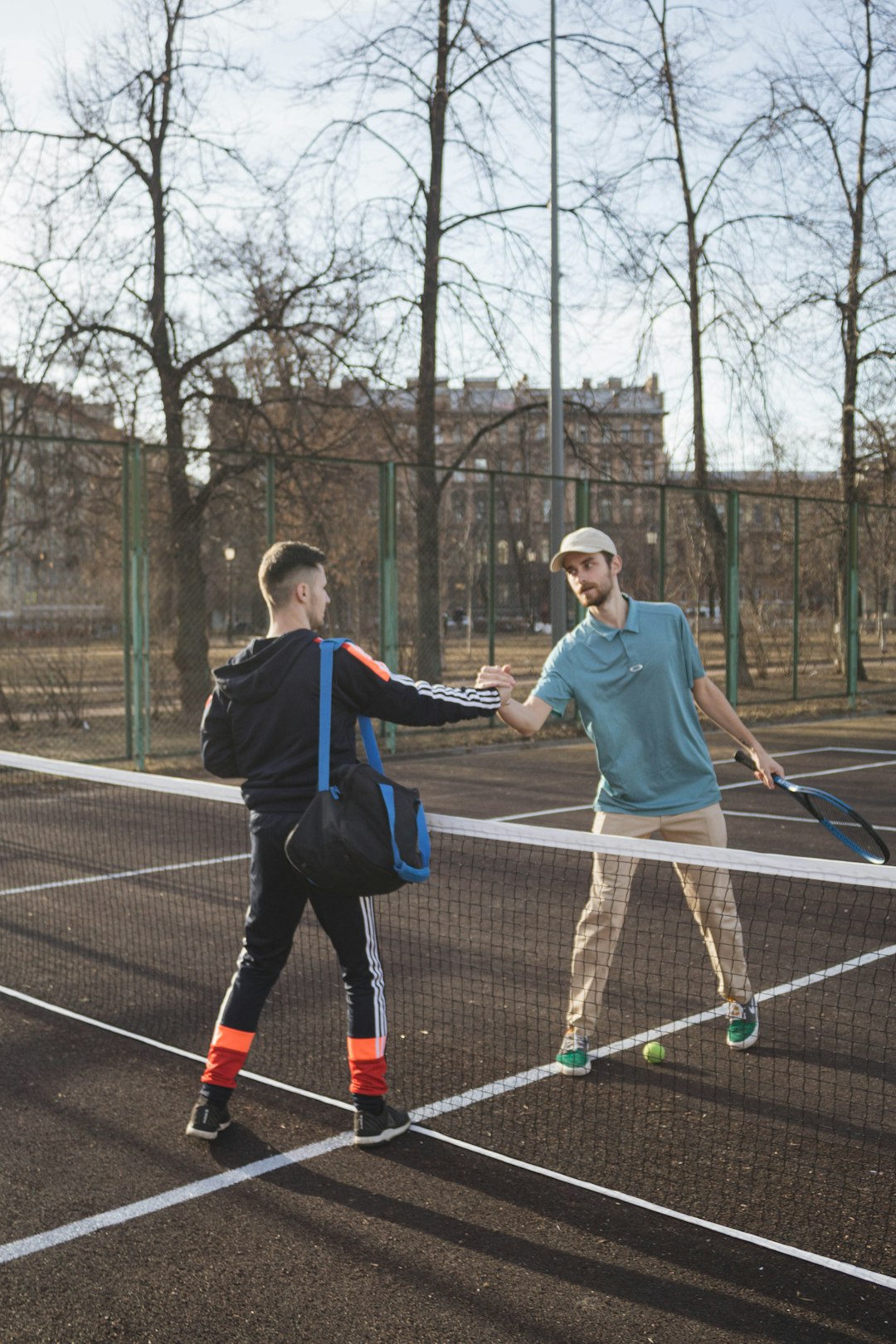 2 men playing tennis on court during daytime