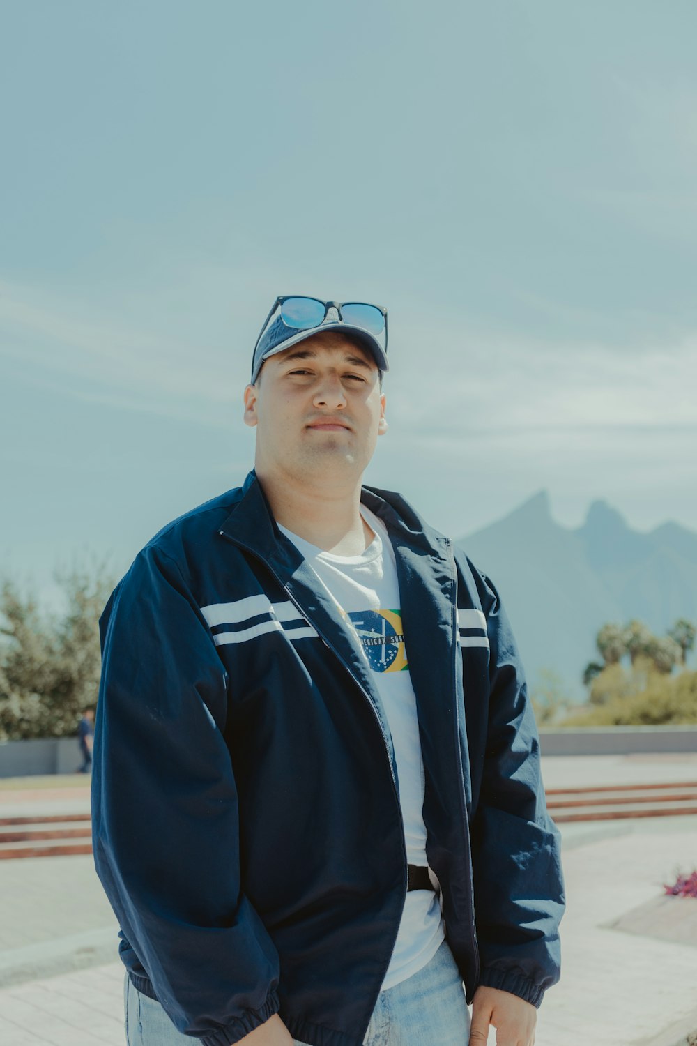 man in blue and white zip up jacket wearing black sunglasses