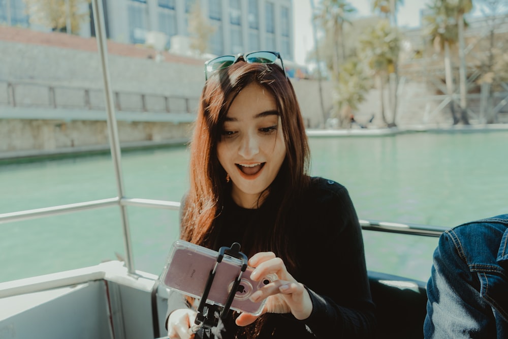 woman in black long sleeve shirt holding black camera