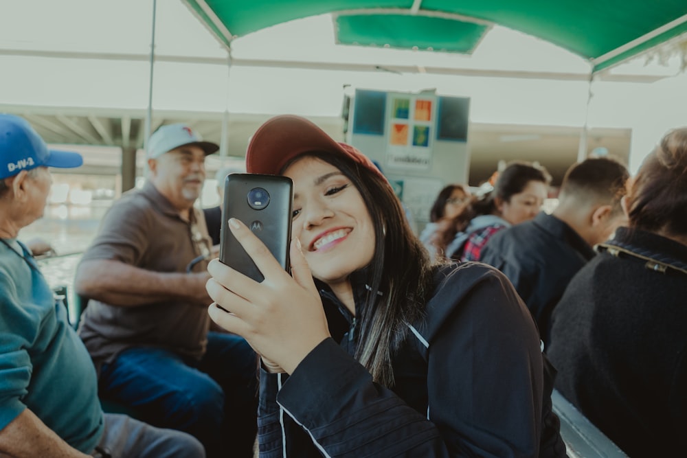 woman in black long sleeve shirt holding black smartphone