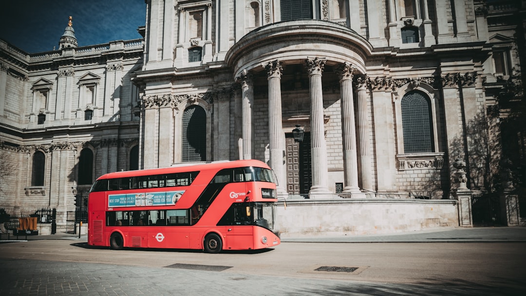 red bus on road near building during daytime