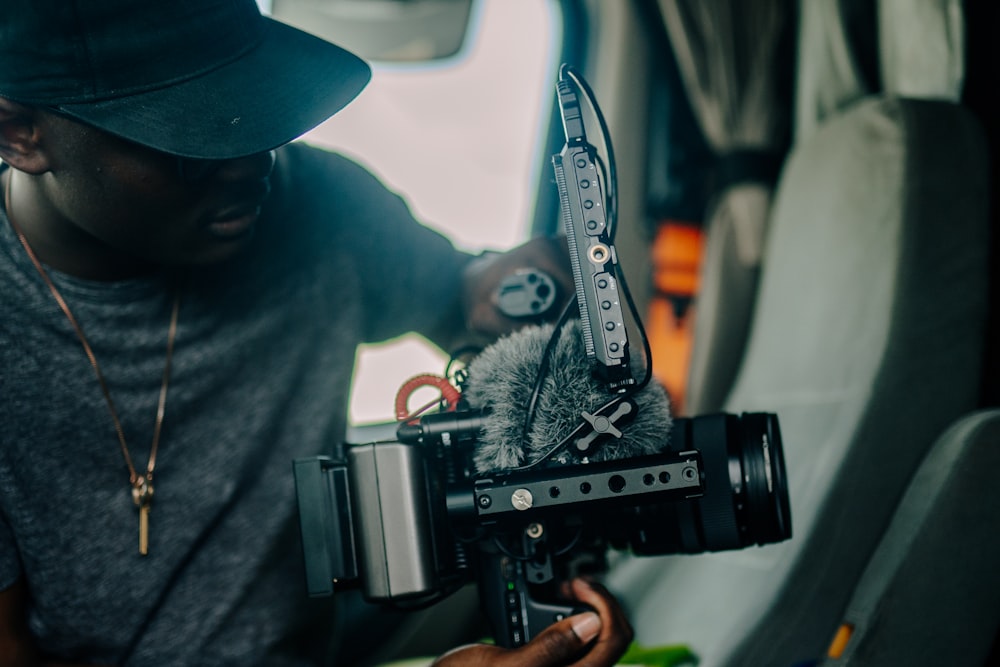 man in black hoodie holding black video camera