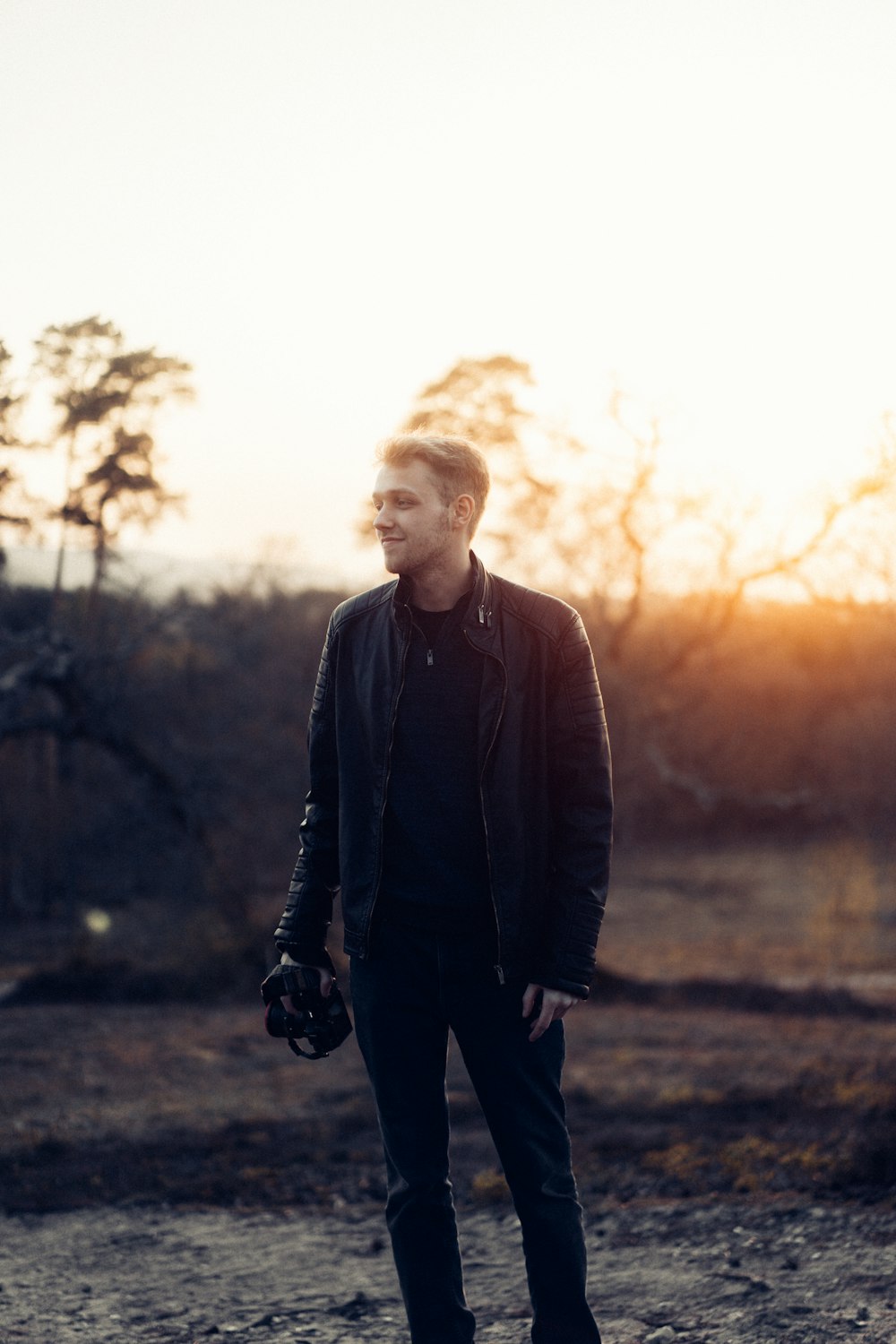 man in black jacket standing on field during daytime