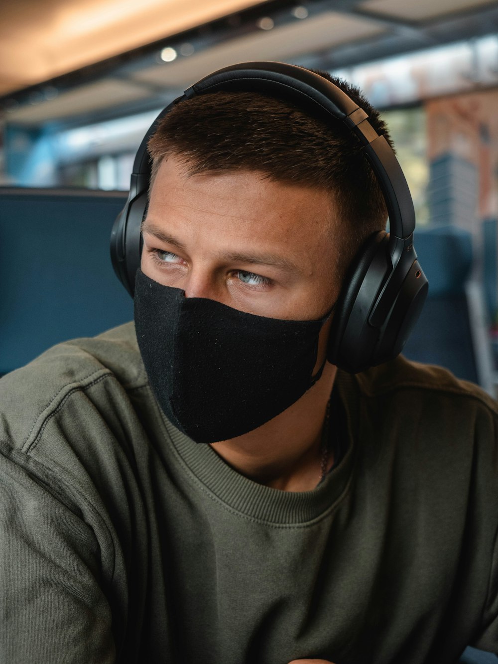 man in grey crew neck shirt wearing black headphones