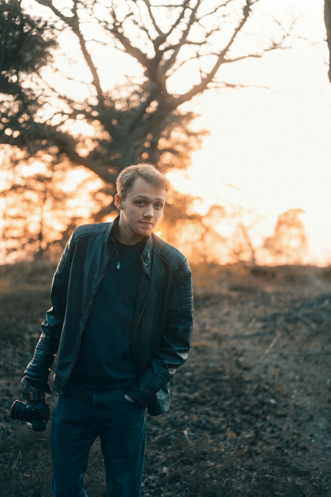 man in black jacket standing near trees during daytime