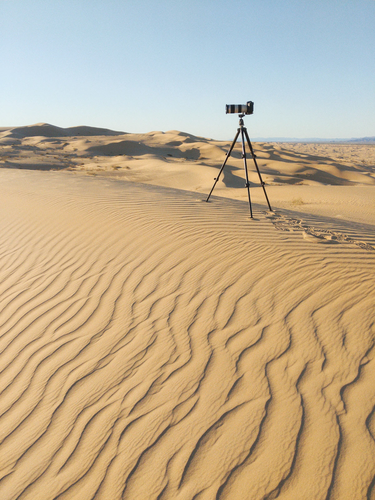 A black camera resting on brown sand
