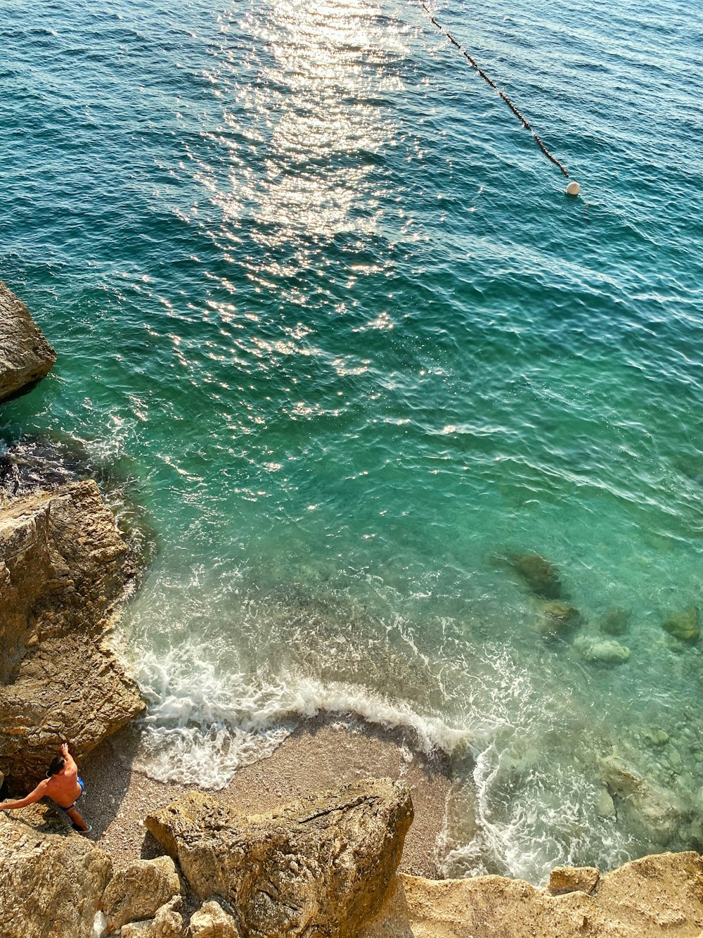 brown rock formation beside body of water during daytime