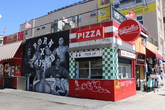 A lively local pizzeria decorated with vibrant promotional posters connecting neighborhood businesses.