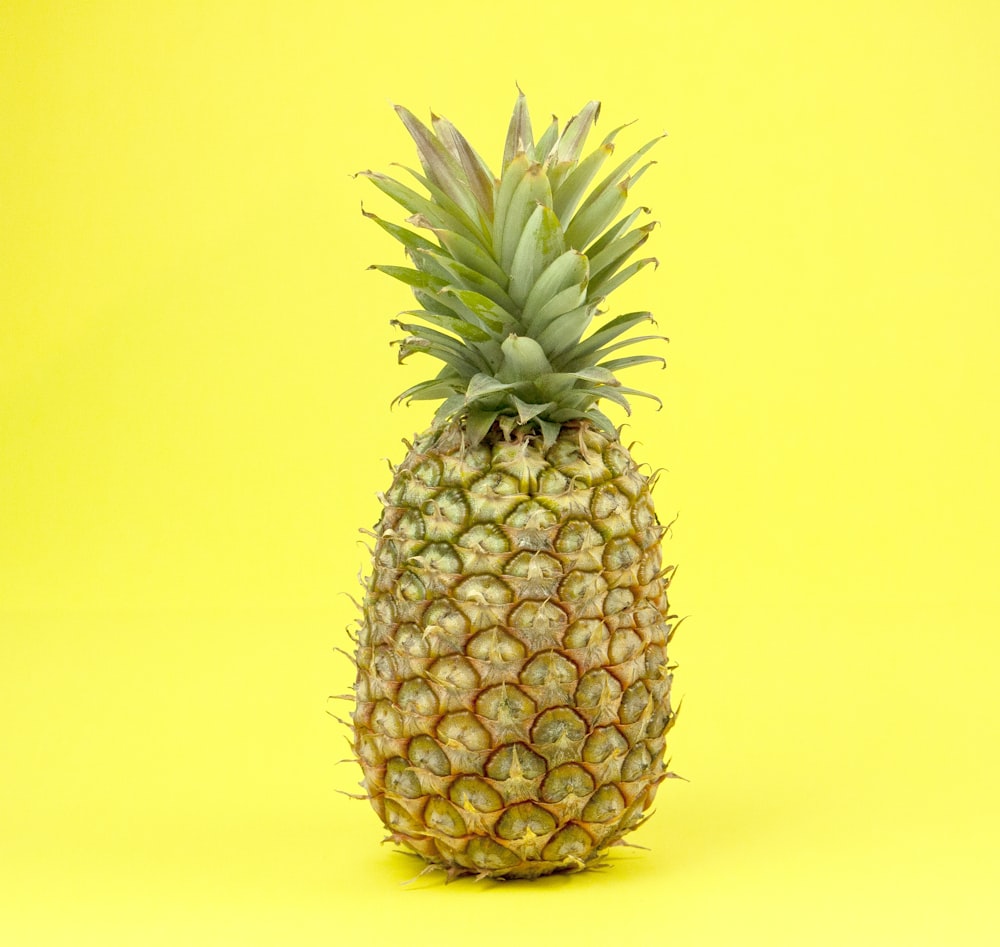 pineapple fruit on yellow surface