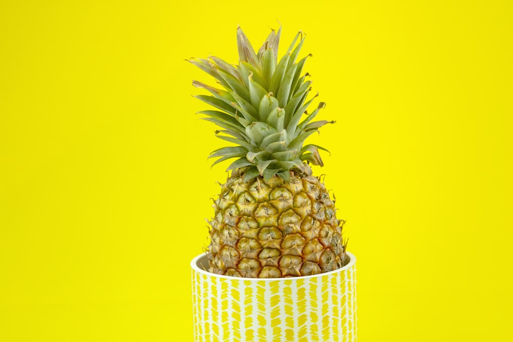 pineapple fruit in yellow and white basket