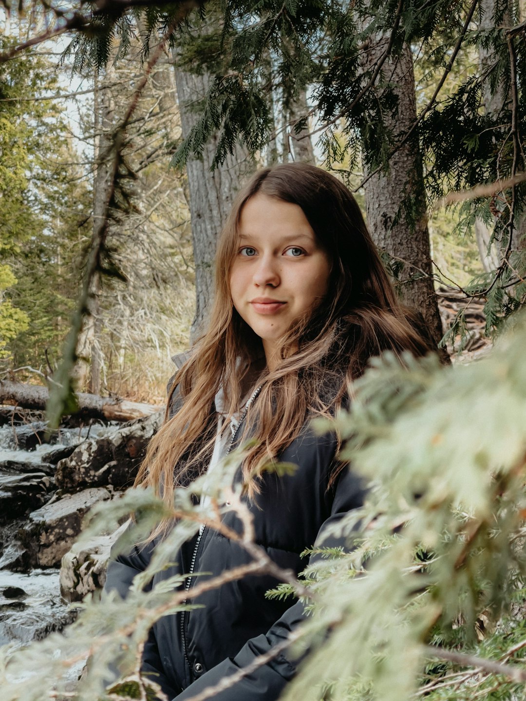 woman in black long sleeve shirt standing near green leaf tree during daytime