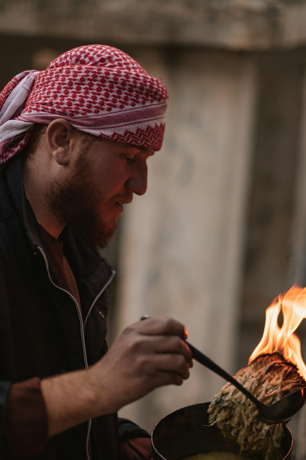 man in red and white plaid hat holding fire