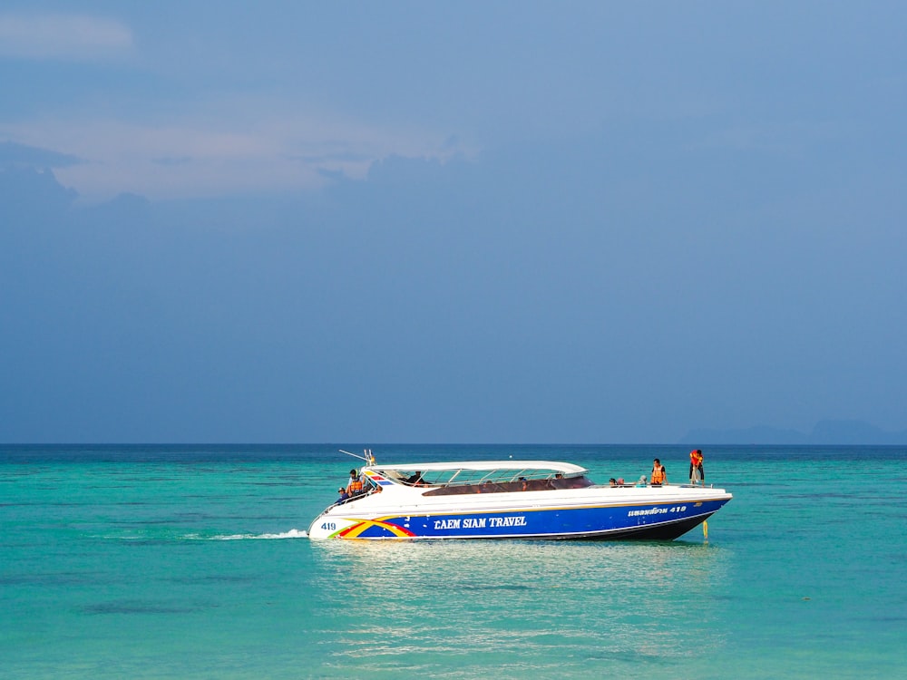 Barco blanco y azul en el mar bajo el cielo azul durante el día